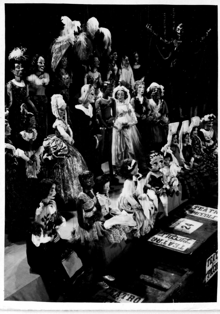 gruppo di marionette femmine su palcoscenico con sipario alle spalle