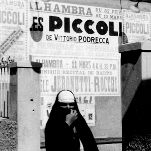 donna davanti al cartellone pubblicitario dello spettacolo dei Piccoli di Podrecca